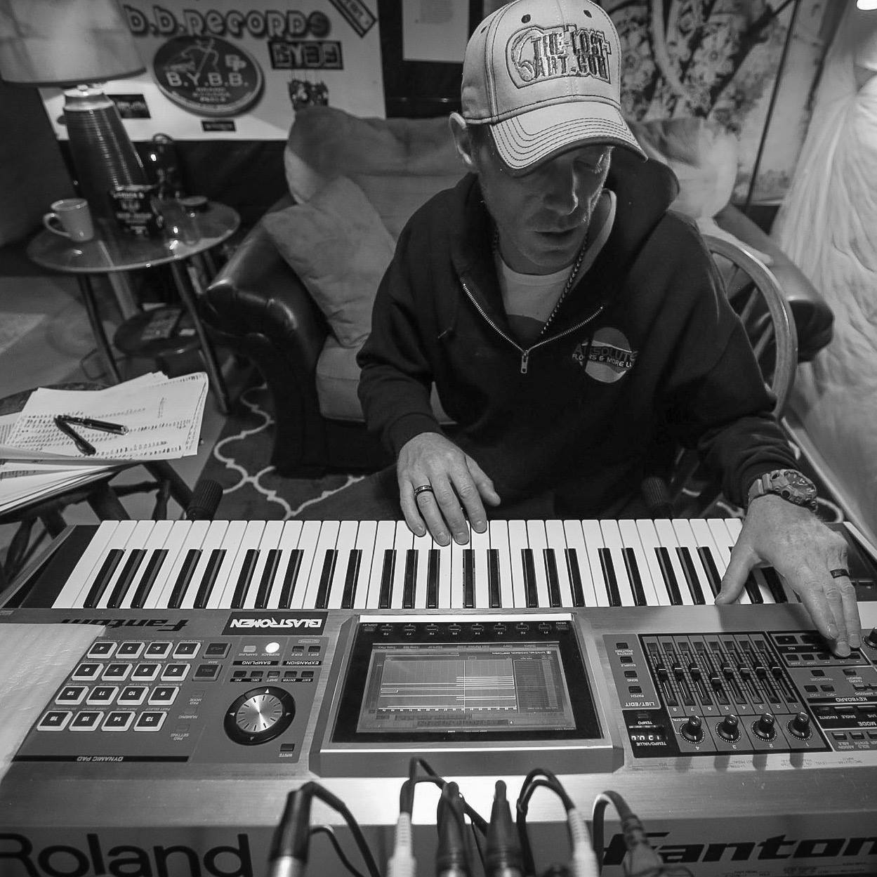DJ Natural Nate® at the Roland Fantom keyboard in black and white, The-Lost-Art™ hat
